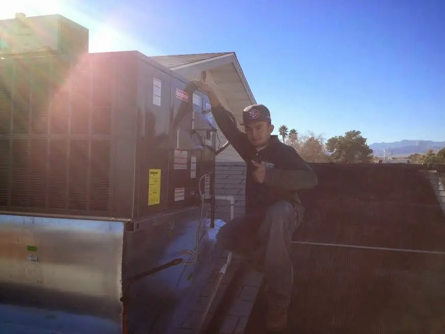 HVAC technician performing Heat Pump Repair on a rooftop unit in Scarsdale